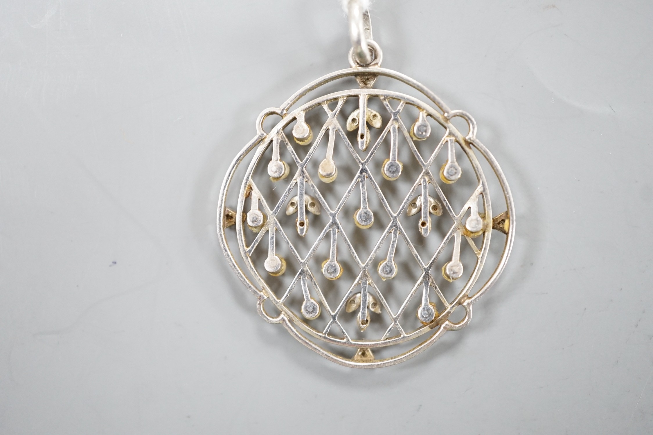 An early 20th century white metal, rose cut diamond chip and seed pearl set openwork pendant, diameter 31mm, gross weight 5.5 grams.
